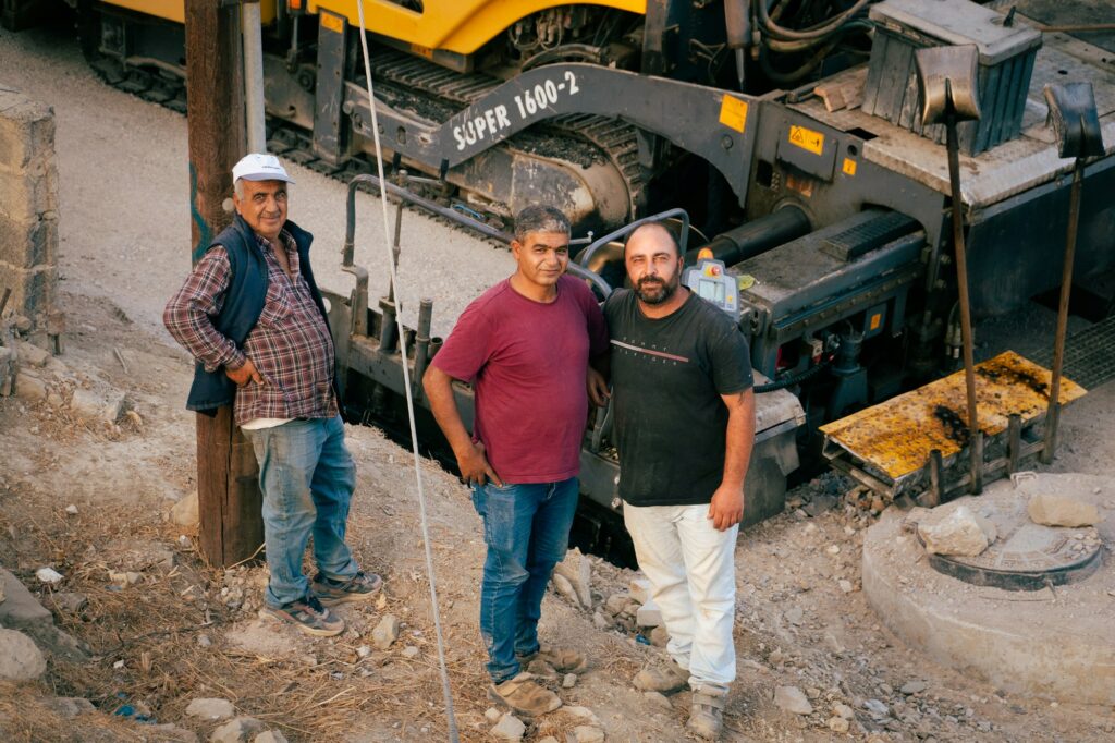 Work crew standing by construction equipment